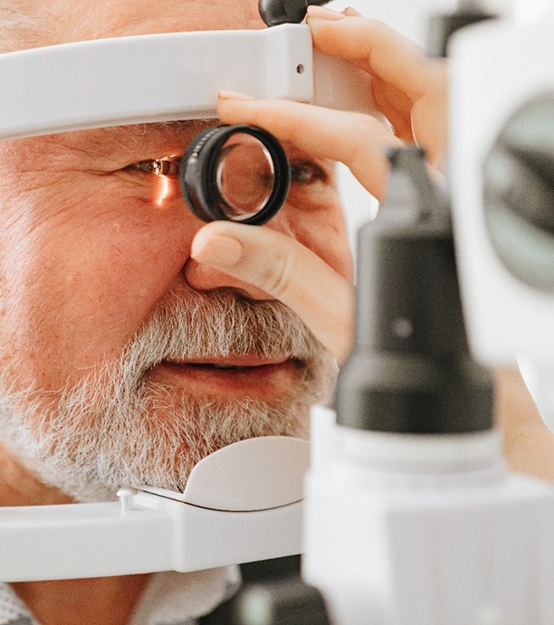 Older man having eye examined with a slit lamp