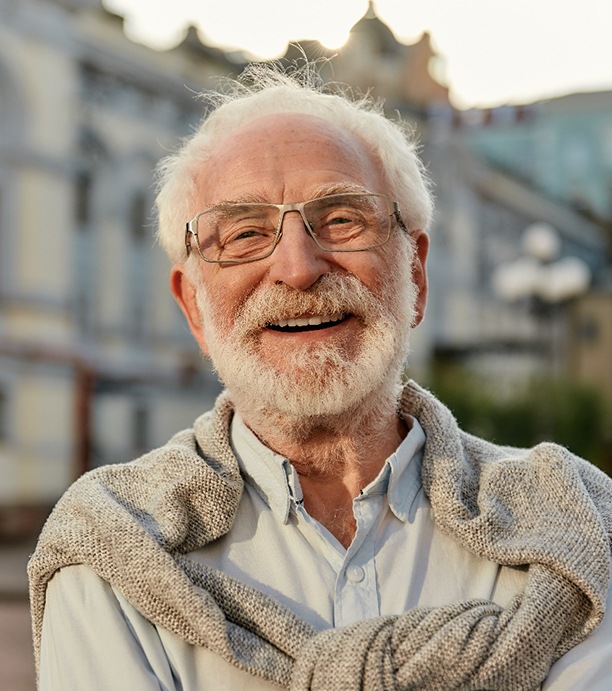Bearded man with glasses smiling outdoors