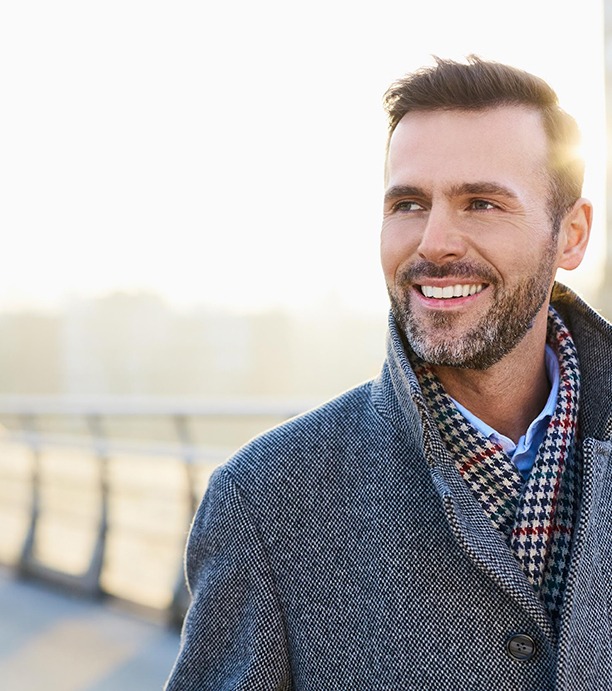 Man in grey coat walking down street