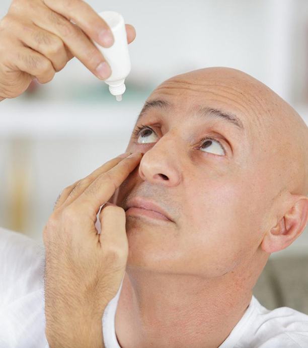 Woman sitting at tonometer for diagnosing glaucoma