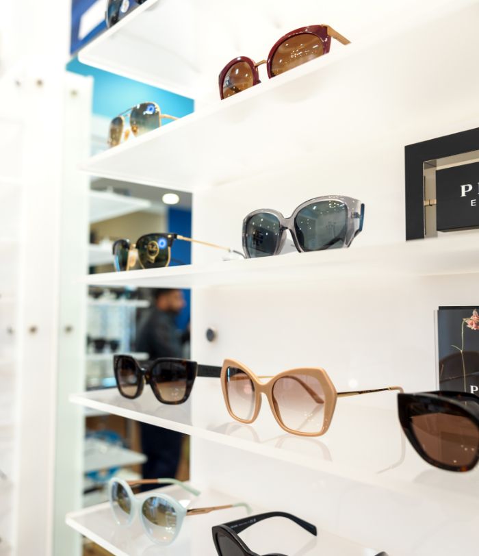 Several different kids of sunglasses on a display shelf