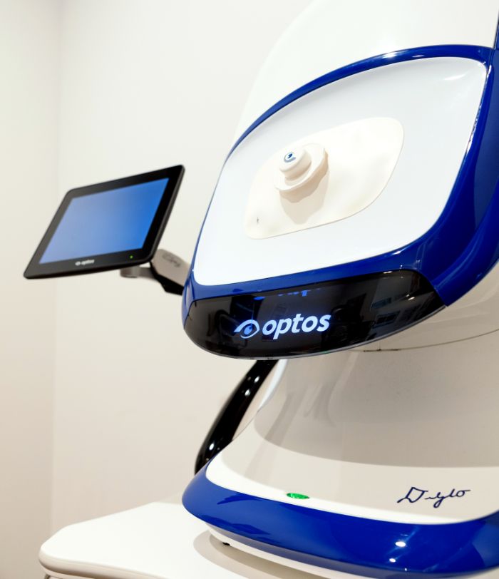 Large white optometry device labeled Optos