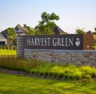 Brick sign in a grassy field reading Harvest Green