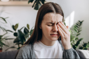 Woman with eye injury touching her eye