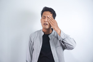 Man with eye injury touching his eye