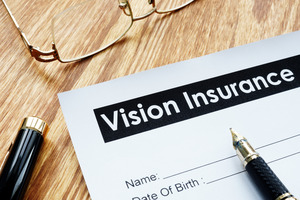 Pen lying on top of vision insurance form on desk